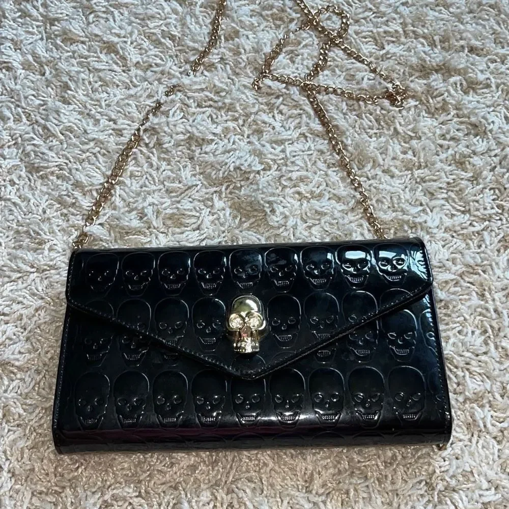 Awesome patent leather skull embossed clutch bag with gold chain shoulder strap.